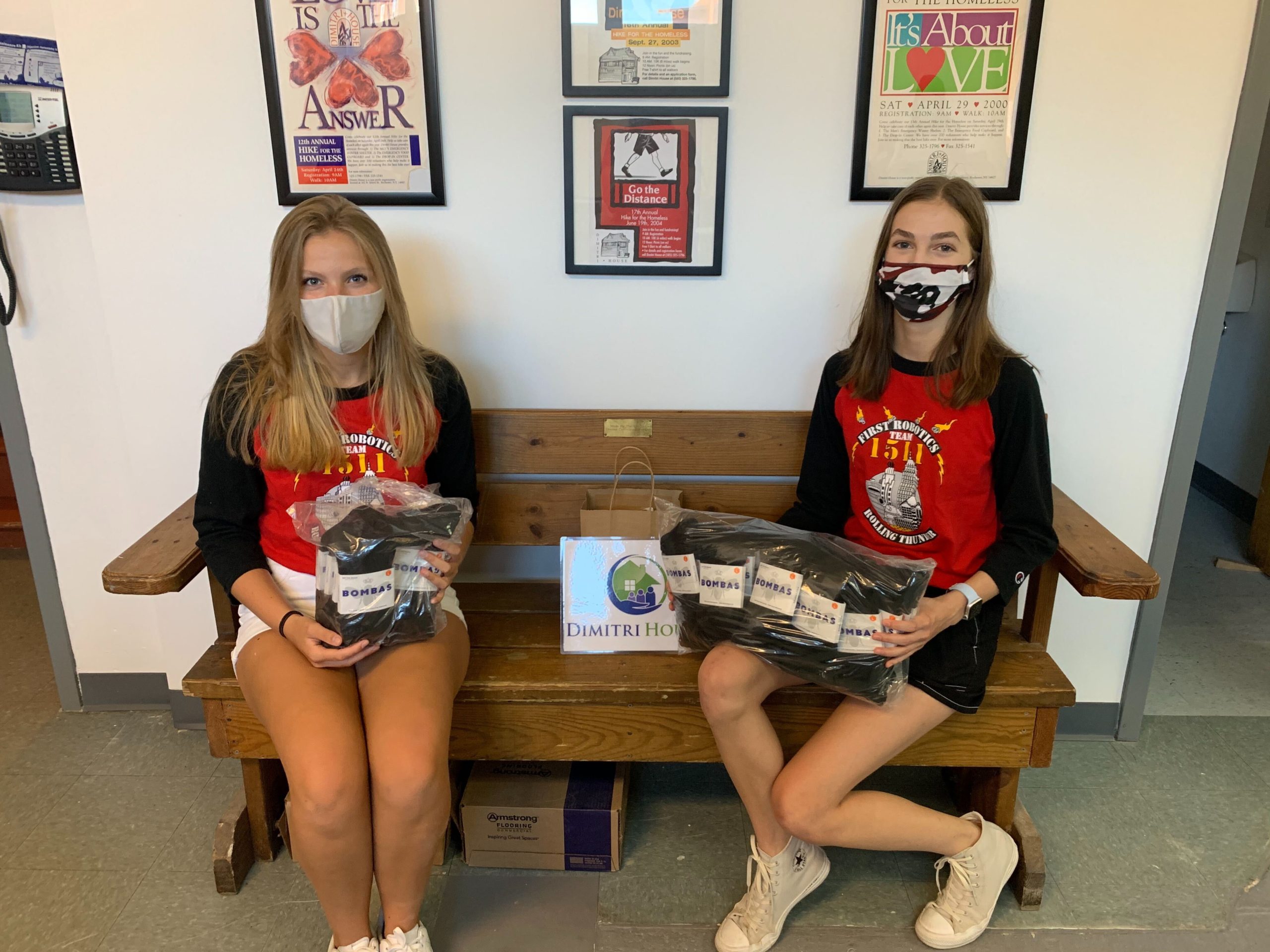 2 students hold packages of Boombas Socks donations at Dimitri House