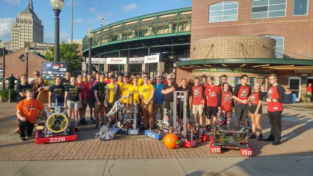 Photo of 4 robotics teams with their robots in from on Frontier Field Stadium in Rochester, NY