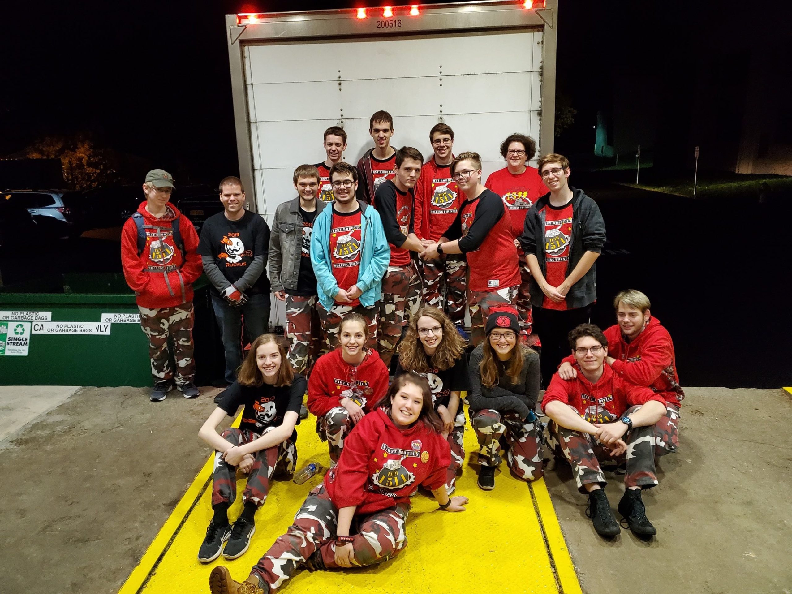 Photo of team members in uniforms at a loading dock in front of a U-Haul truck while unloading form Rah Cha Cha Cha Ruckus Event