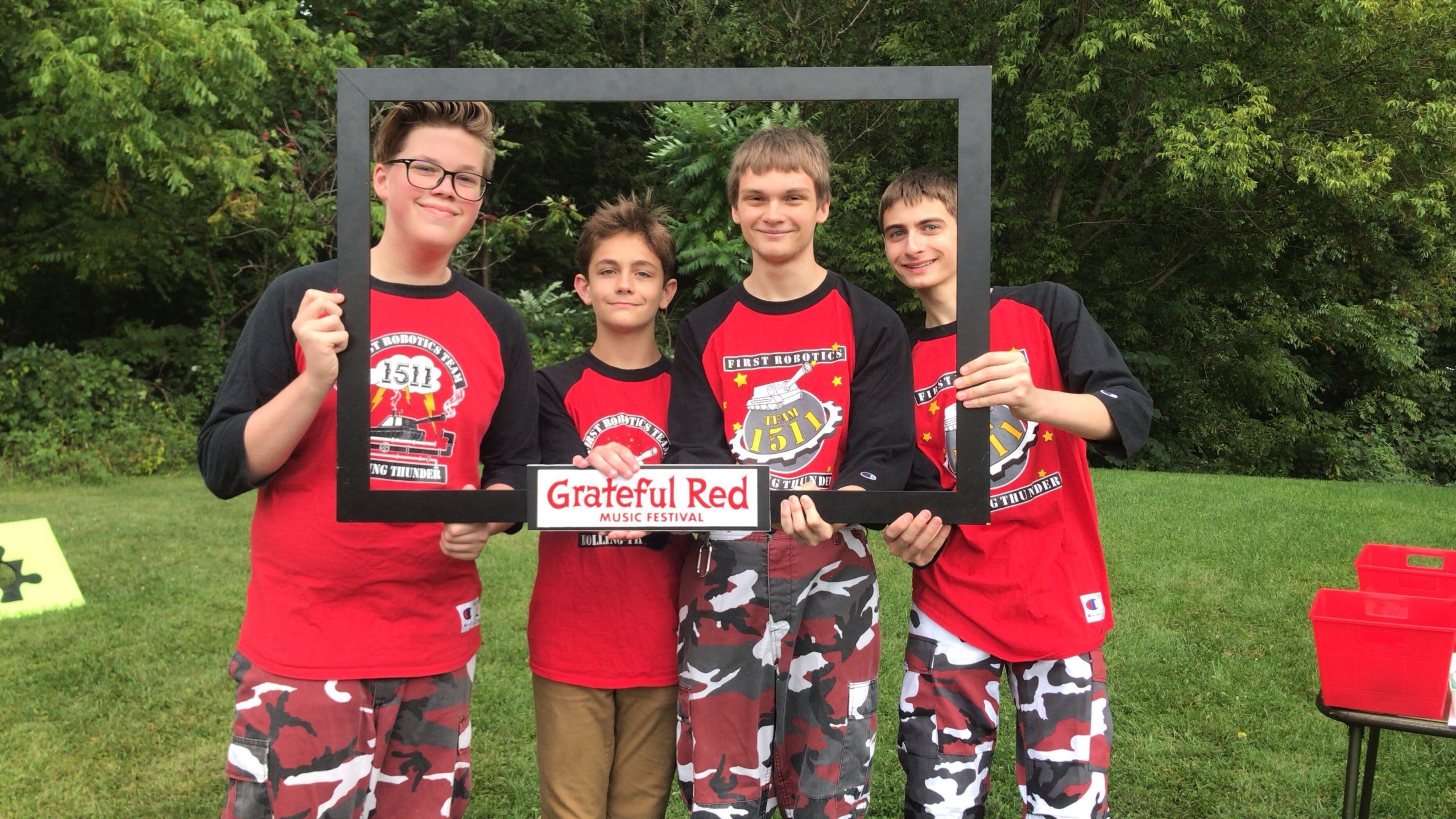 Photo of 4 students hold a Grateful Red Music Festival frame