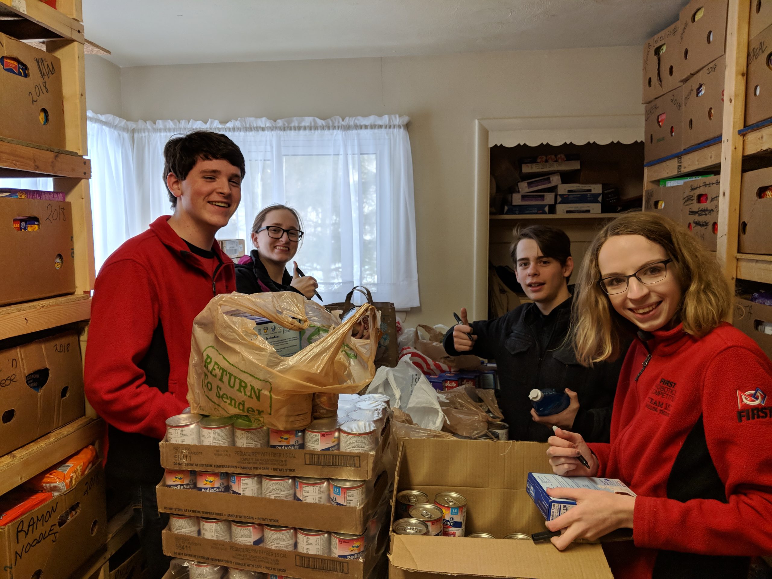 4 Team members unpacking boxes of food at Penfield Ecumenical Food Shelf