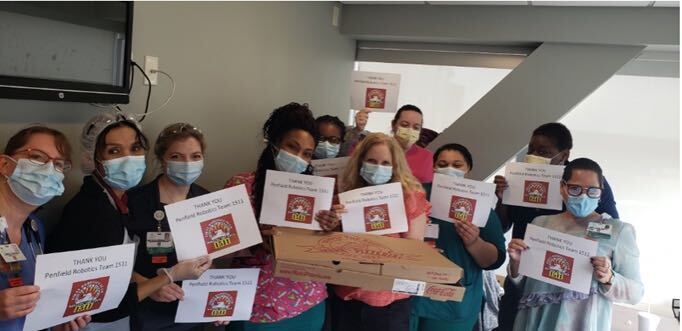 Healthcare workers holding Thank You 1511 Signs for pizza delivery