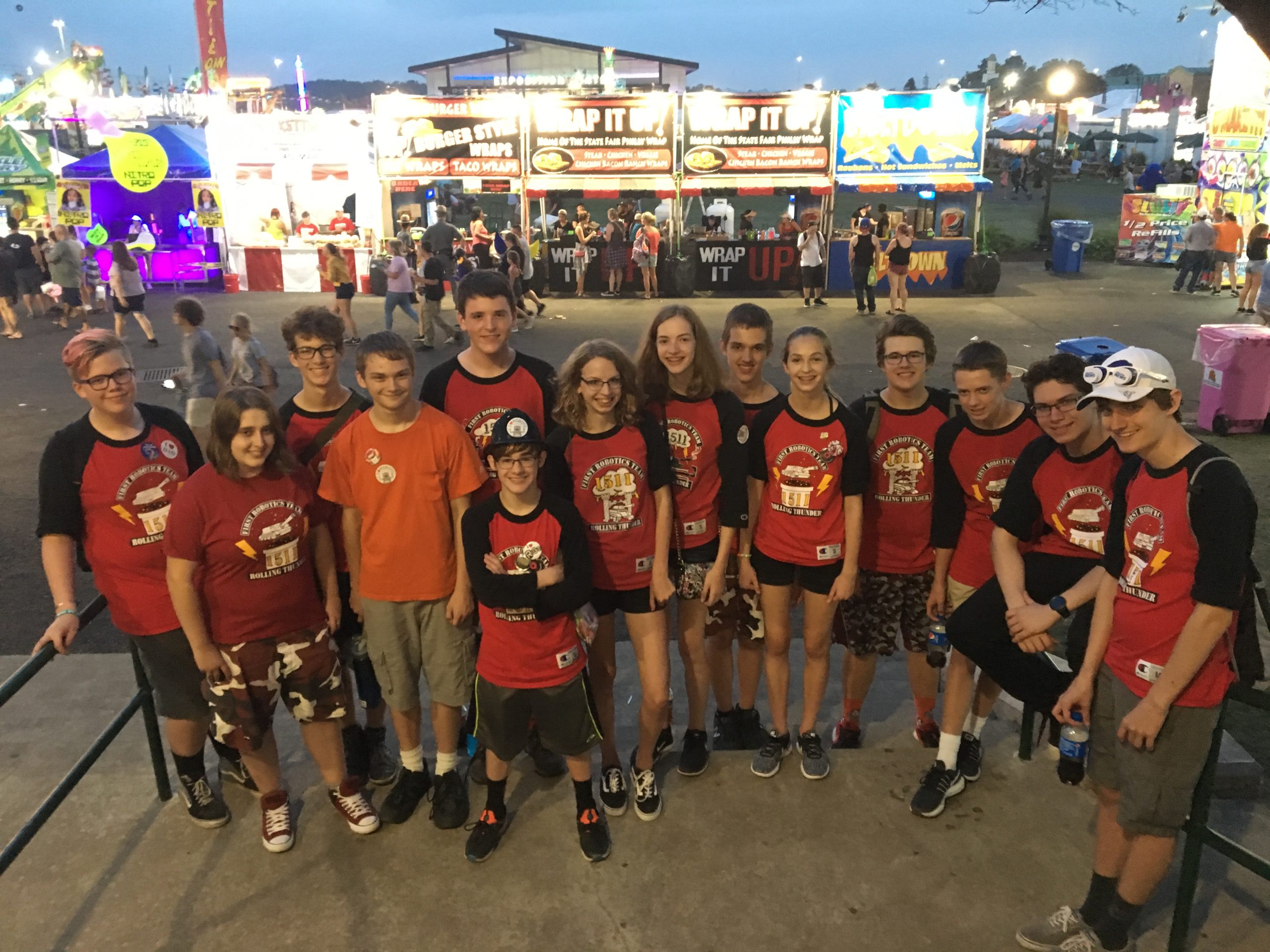 Members of FRC Team 1511 posing in front of booths at New York State Fair
