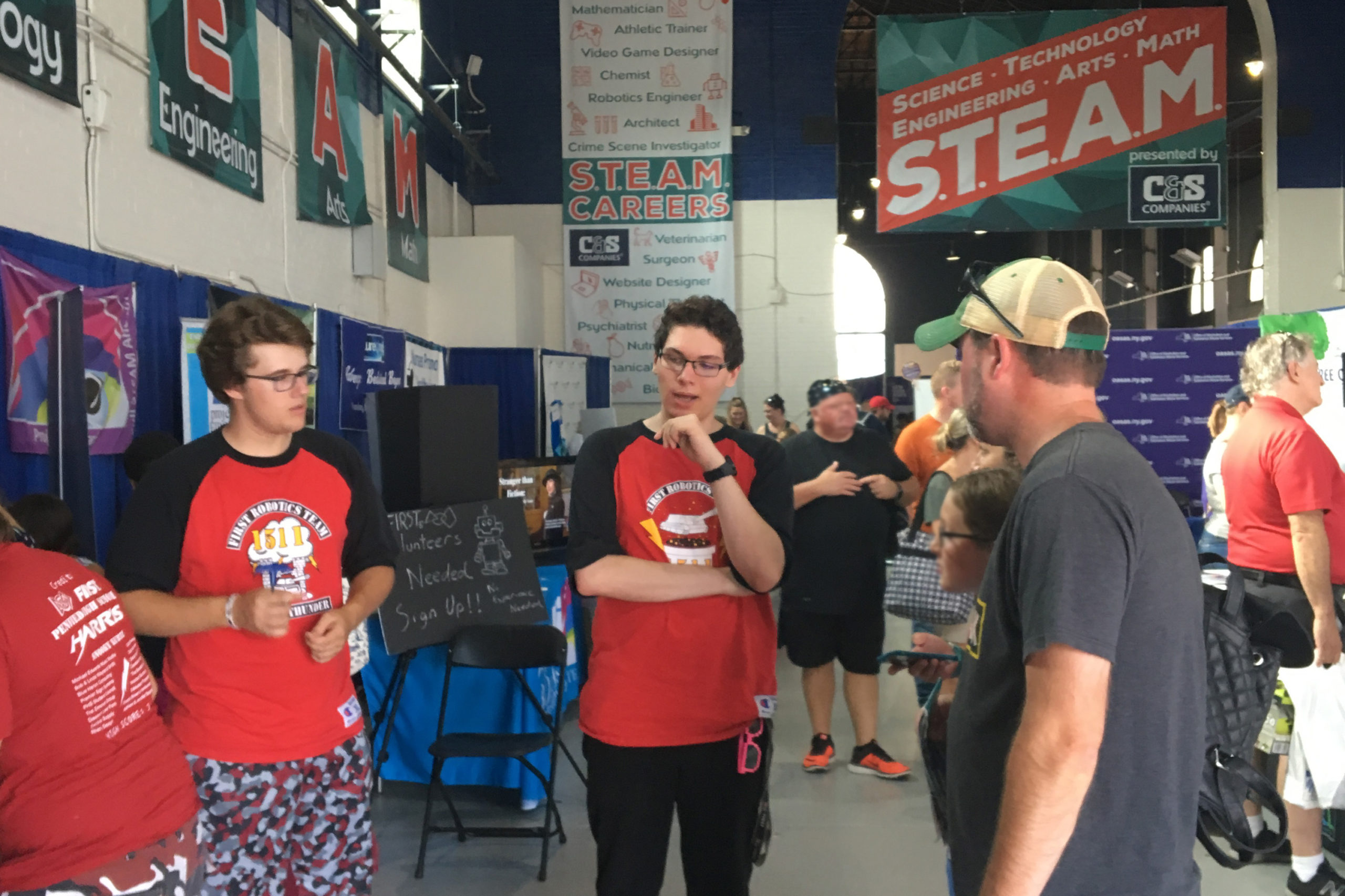 2 students talk to spectators at New York State Fair