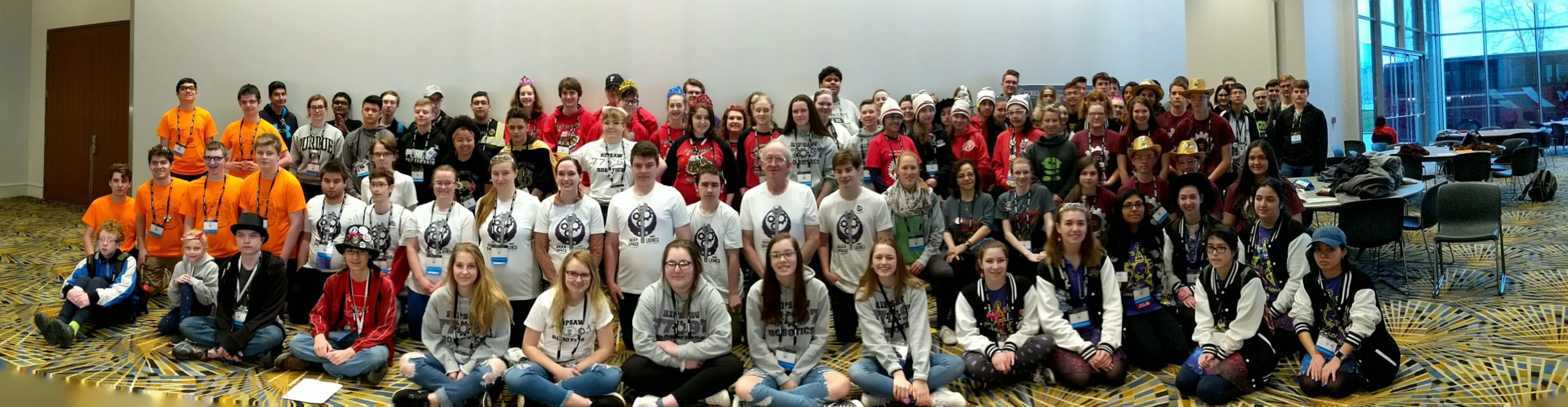 Group photo of robotics teams in uniforms at 2019 FIRST Detroit Championship All Rookie Meet and Greet