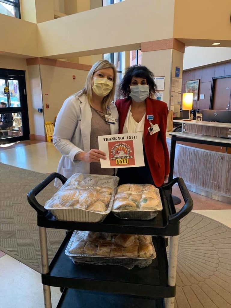 Hospital workers in front of a cart of sandwiches donated by Team 1511